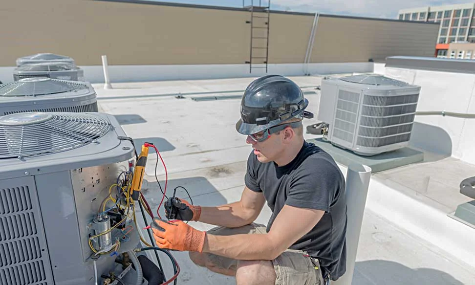 HVAC technician working with rooftop heating and cooling equipment