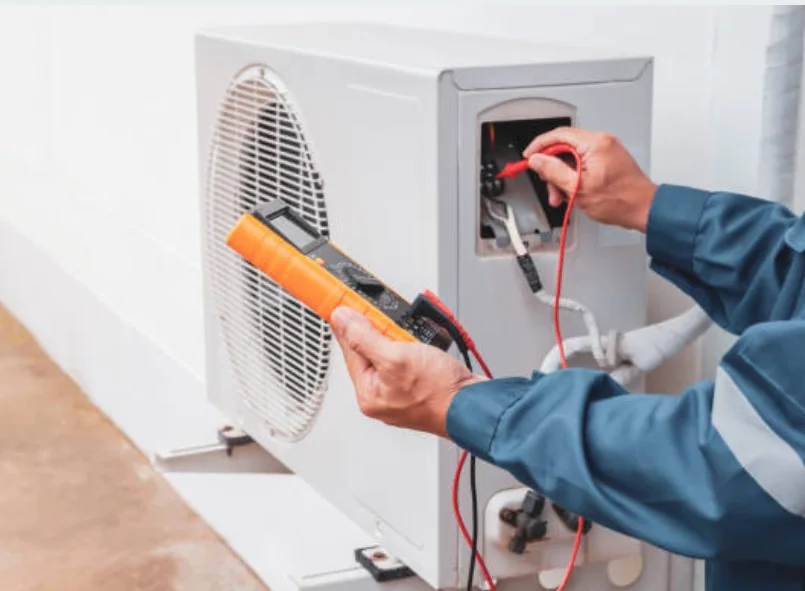 Technician testing electrical components inside a residential heat pump system
